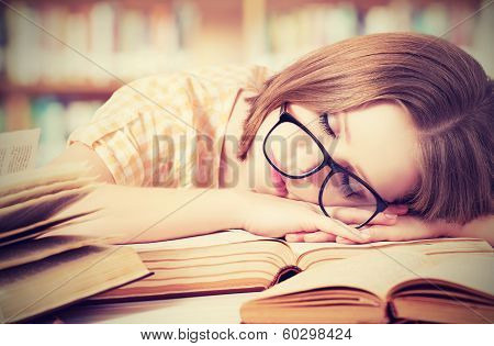 Tired Student Girl With Glasses Sleeping On Books In Library