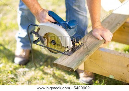 Detail of circular saw cutting piece of wood