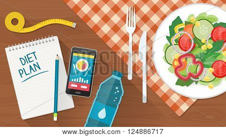 Food diet healthy lifestyle and weight loss banner with a dish of salad table set smartphone and diet plan on a notebook