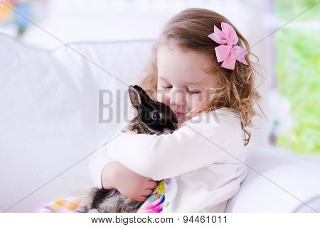 Little Girl Playing With A Real Pet Rabbit