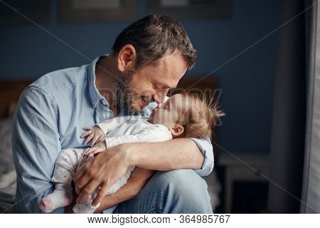 Middle Age Caucasian Father Kissing Sleeping Newborn Baby Girl. Parent Holding Rocking Child Daughte