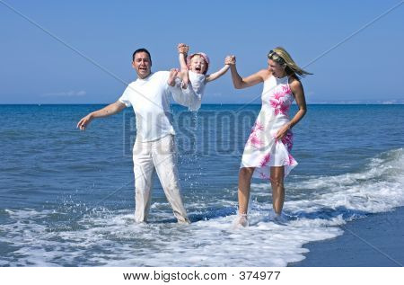 junge Familie spielen mit Tochter am Strand in Spanien