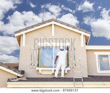 Busy House Painter Painting the Trim And Shutters of A Home.