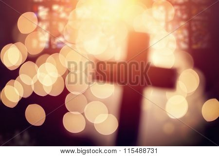 Abstract defocussed cross silhouette in church interior against stained glass window concept for religion and  prayer