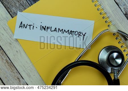 Concept Of Anti - Inflammatory Write On Sticky Notes With Stethoscope Isolated On Wooden Table.