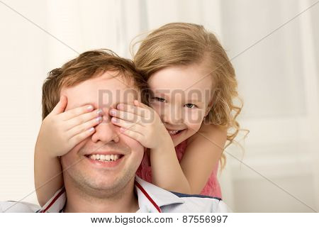 Daughter playing with father closing his eyes