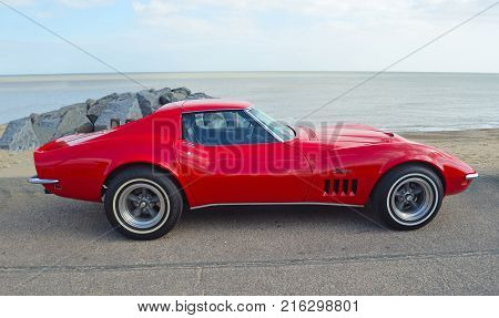 FELIXSTOWE, SUFFOLK, ENGLAND -  MAY 07, 2017: Classic Red Chevrolet Corvette Stingray  Motor Car Parked on Seafront Promenade.