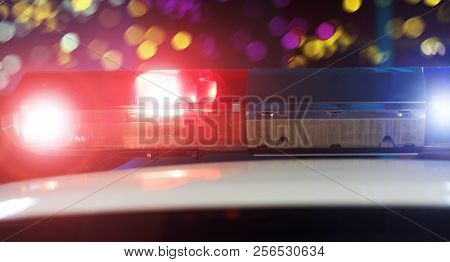 Police Patrol Car Of The Specialized Unity In The Night Time. Red And Blue Flashes On The Car Of The