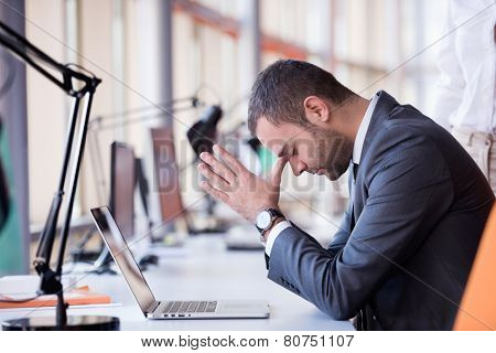 frustrated young business man working on laptop computer at office