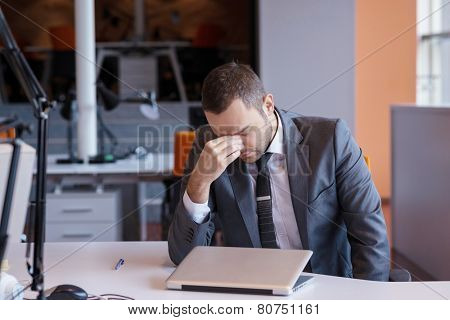 frustrated young business man working on laptop computer at office