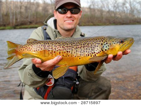 Fisherman holding large trout - Fly fishing