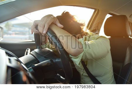 Tired Asian Business woman sleeping while driving a car with bad traffic jam on rush hours. Illness exhausted disease for overtime working concept.