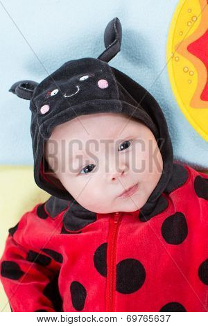 Pretty Baby Girl, Dressed In Ladybug Costume On Green Background. The Concept Of Childhood And Holid