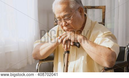 Pensive Disabled Elderly Patient Sit On Wheelchair Alone, Sad And Depressed Lonely Asian Senior Old 