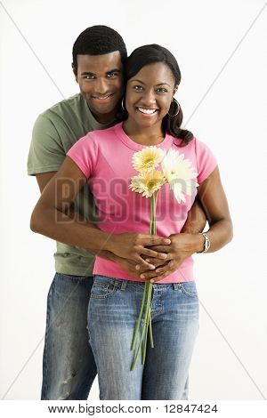 Portrait of smiling African American couple standing looking at viewer.