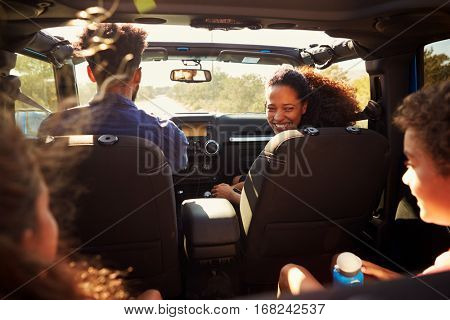 Excited family on a road trip in car, rear passenger POV