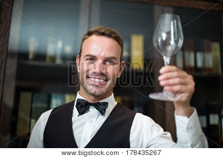 Portrait of waiter holding wine glass in a fancy restaurant