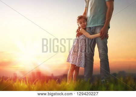 Happy loving family. Father and his daughter child girl playing and hugging outdoors. Cute little girl hugs daddy. Concept of Father's day.