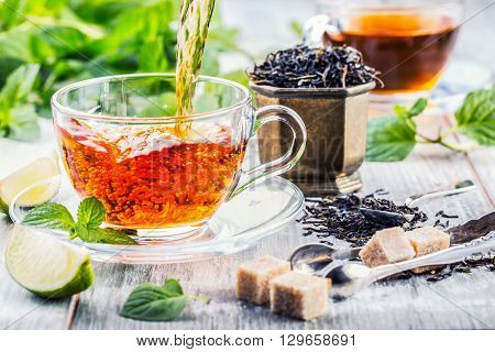 Tea. Mint Tea. Herbal tea. Mint leaf. Mint leaves. Tea in a glass cup mint leaves dried tea sliced lime. herbs tea and mint leaves on a slate plate in a restaurant or teahouse tea room.