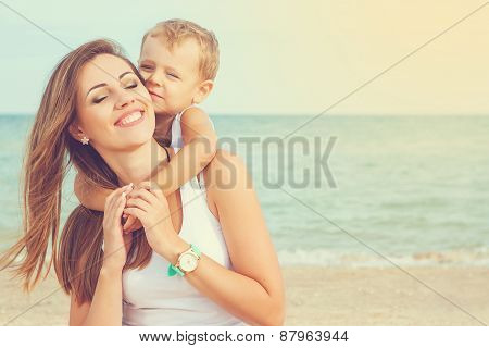 Mother And Her Son Having Fun On The Beach