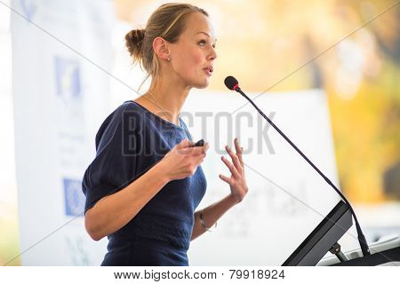 Pretty, young business woman giving a presentation in a conference/meeting setting (shallow DOF; color toned image)