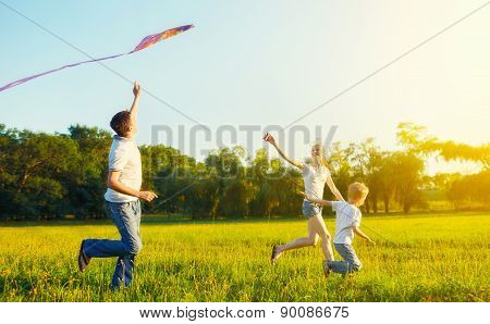 Dad, Mom And Son Child Flying A Kite In Summer Nature