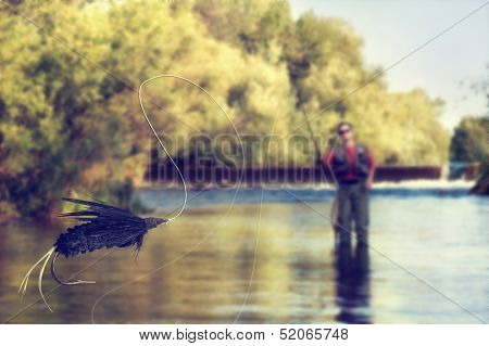 a person fly fishing in a river with a fly in the foreground