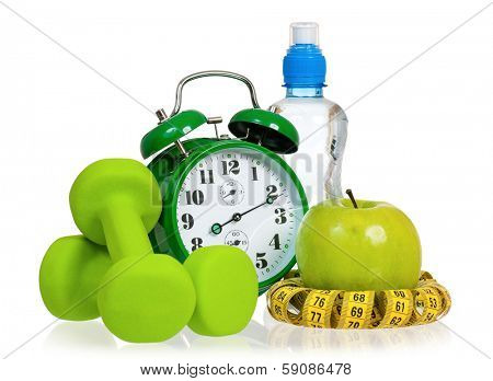 Green alarm clock, apple, bottle of water,  measuring tape and dumbbells as concept of diet - isolated on white 