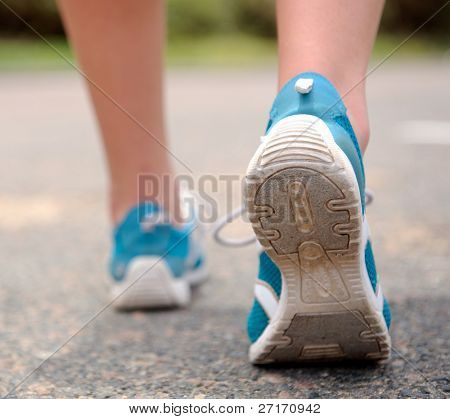 Close up motion shot of person walking away in running shoes