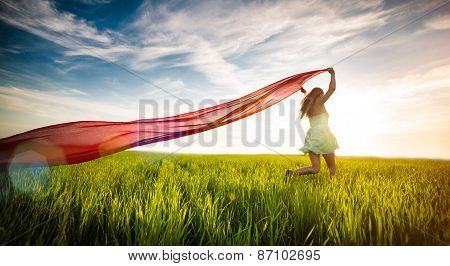 Young happy woman in wheat field with fabric. Summer lifestyle