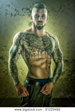 Tattoo unique muscle-building man standing in front of the wall