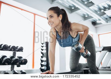 Young Beautiful Woman Doing Exercises With Dumbbell In Gym.