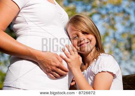 pregnancy - girl touching belly of pregnant mother