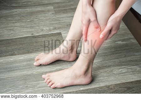 Closeup Of Woman Hands Holding And Massage Her Calf, Suffering From Calf Pain. Calf Pain May Be Musc