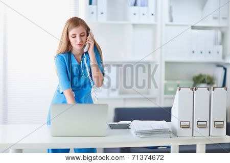 Medical doctor woman with computer and telephone.