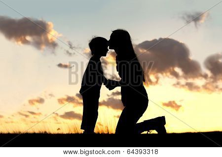 Mother Lovingly Kissing Little Child At Sunset