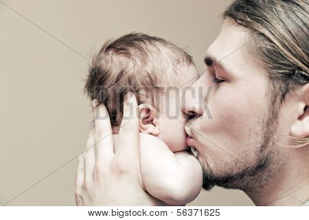 Vater mit seinem jungen Baby Kuscheln und ihn auf die Wange küssen. Elternschaft, Liebe.