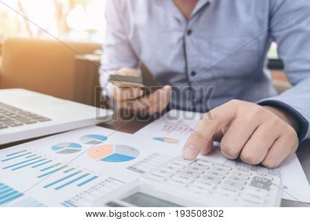 Business Financing Accounting Banking Concept businessman using smart phone and doing finances calculate about cost to real estate investment and in other tax system.