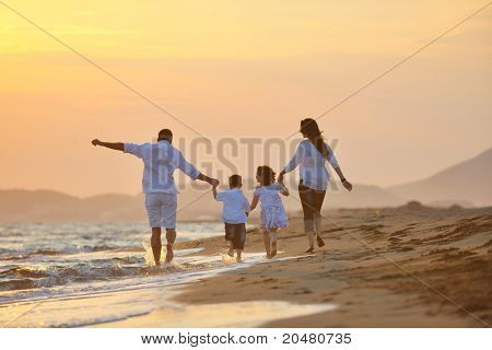 glücklich junge Familie viel Spaß am Strand laufen und springen bei Sonnenuntergang