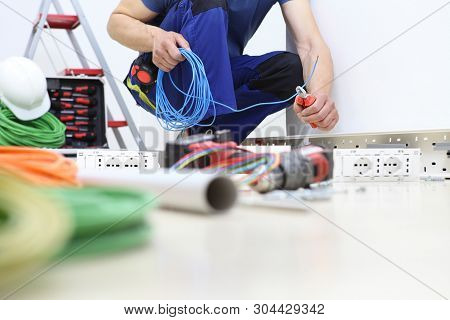 Electrician At Work With Nippers In Hand Cut The Electric Cable, Install Electric Circuits, Electric