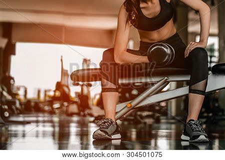 Working Out With Dumbbell Weights At The Gym.fitness Women Exercising Are Lifting Dumbbells With A W