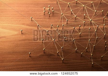 Linking entities. Large network. Network, networking, social media, internet communication abstract. Many small network connected to a larger network. Web of gold wires on rustic wood. 