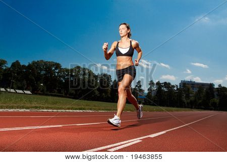 Athletic woman running on track