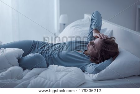 Depressed woman awake in the night she is exhausted and suffering from insomnia