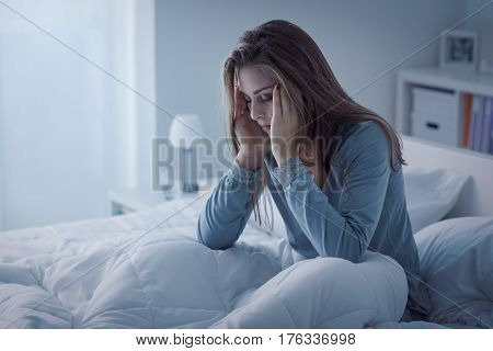 Depressed woman awake in the night she is exhausted and suffering from insomnia