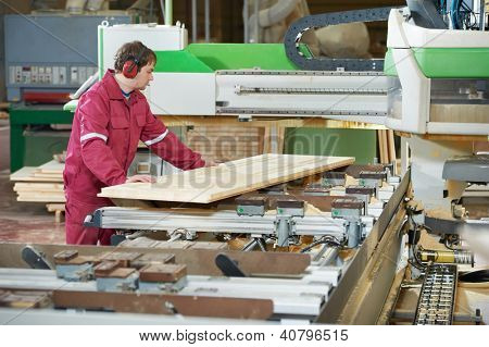 Closeup process of carpenter worker with circular saw machine at wood beam cross cutting during furniture manufacture