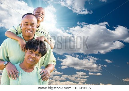 Happy African American Family Over Blue Sky And Clouds