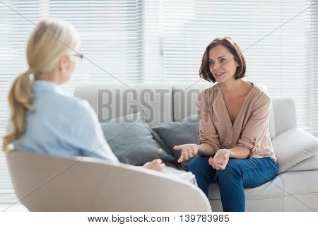 Woman talking to therapist on sofa at home