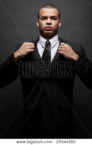 Young handsome African-American businessman in black suit.