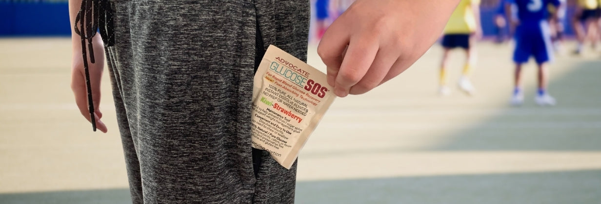 A boy with grey pants pulling a packet of Glucoses SOS out of pocket. 